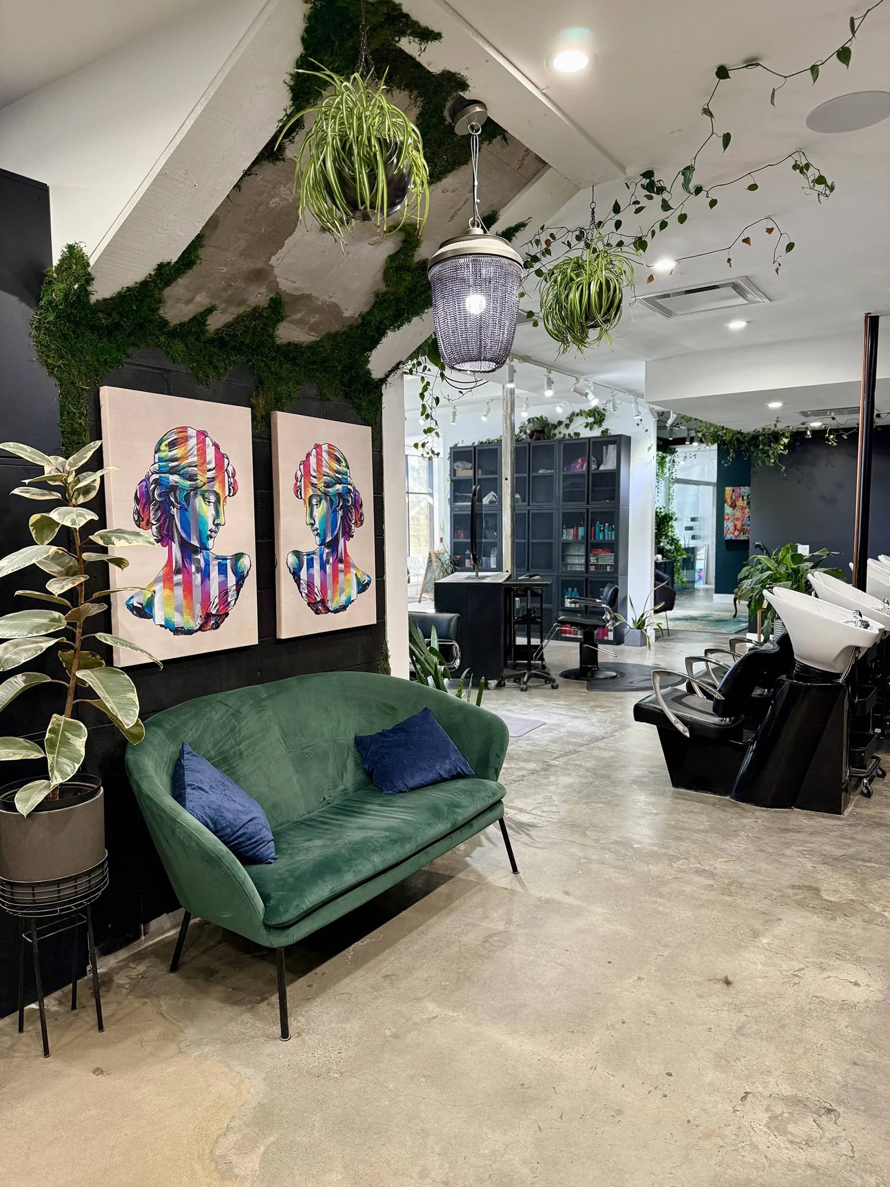 The Level 7 salon in Calgary: a green velvet sofa, plants and pop-art busts